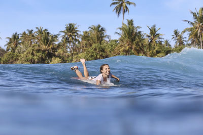 Happy woman enjoying surfing on sea