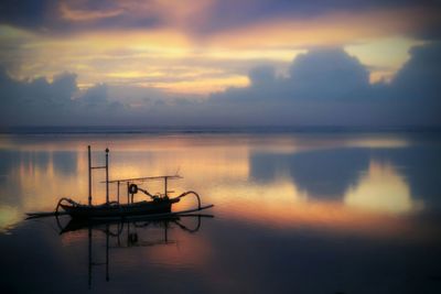 Reflection of clouds in sea at sunset