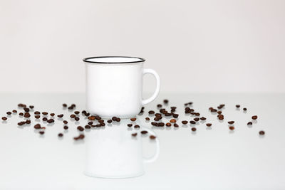 Close-up of coffee cup on table against white background