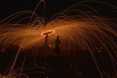 Men spinning wire wool at night