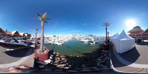 Panoramic view of boats moored on beach against sky