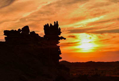 Silhouette of rock formations against sky during sunset