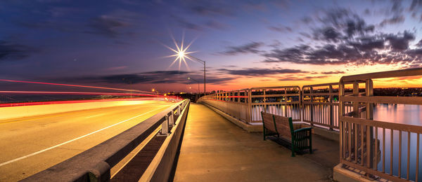 Light trails on road against sky during sunset