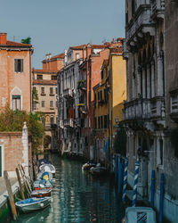 Boats in canal amidst buildings in city