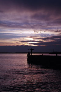 Silhouette boat in sea against sky during sunset