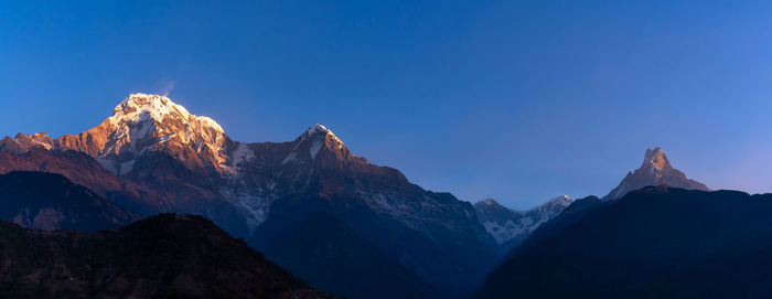 Scenic view of snowcapped mountains against blue sky