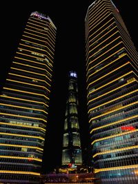 Low angle view of illuminated buildings against sky at night