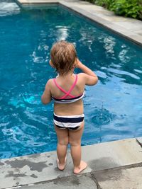 Rear view of woman standing in swimming pool