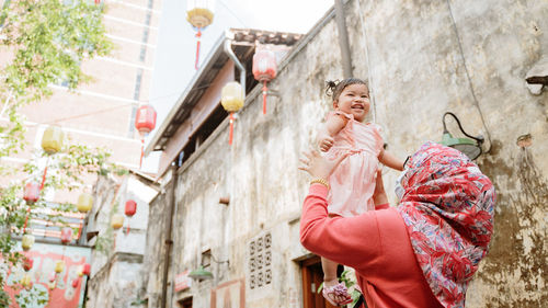 Portrait of a smiling young woman in front of building