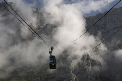 Foggy landscape showing a cable car and a rocky mountain in fuente de in picos de europa in spain