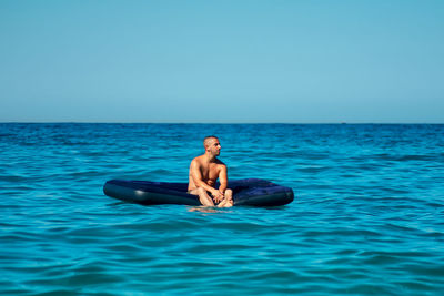 Man in swimming pool against sea