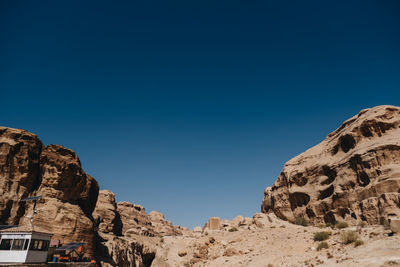 Low angle view of rock formations against clear blue sky