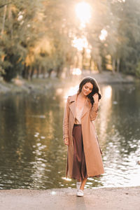 A happy single woman in elegant clothes walks in an fall park and in the forest in autumn outdoors