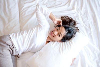 High angle view of woman lying on bed