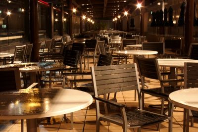 Empty chairs and tables at night