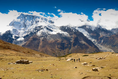 People walking against snowcapped mountains