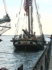 Boats moored at harbor against sky