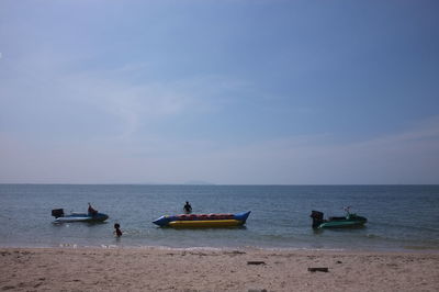 People on beach against sky