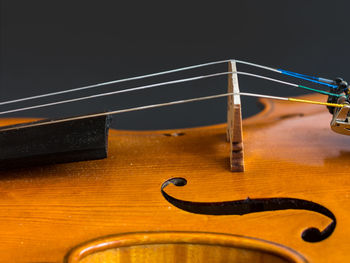 Close-up of guitar on table against black background