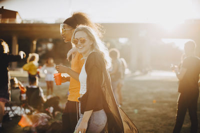 Smiling woman walking with friend at concert
