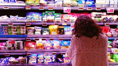 Rear view of woman standing at market stall