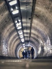 People walking in illuminated tunnel