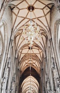 Low angle view of chandelier hanging on ceiling of building