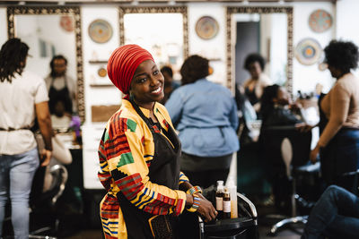 Contemplative female barber looking away in hair salon