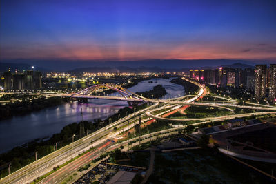 High angle view of illuminated cityscape against sky at night