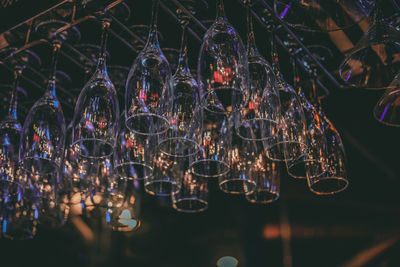 Low angle view of wineglasses hanging on ceiling in bar