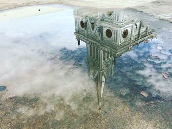 Reflection of building in puddle