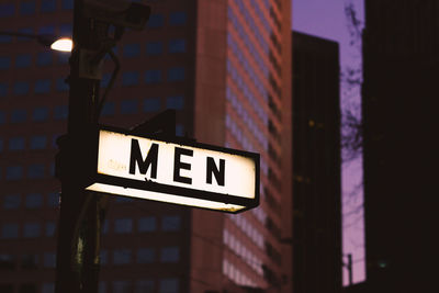 Low angle view of illuminated sign on building at night