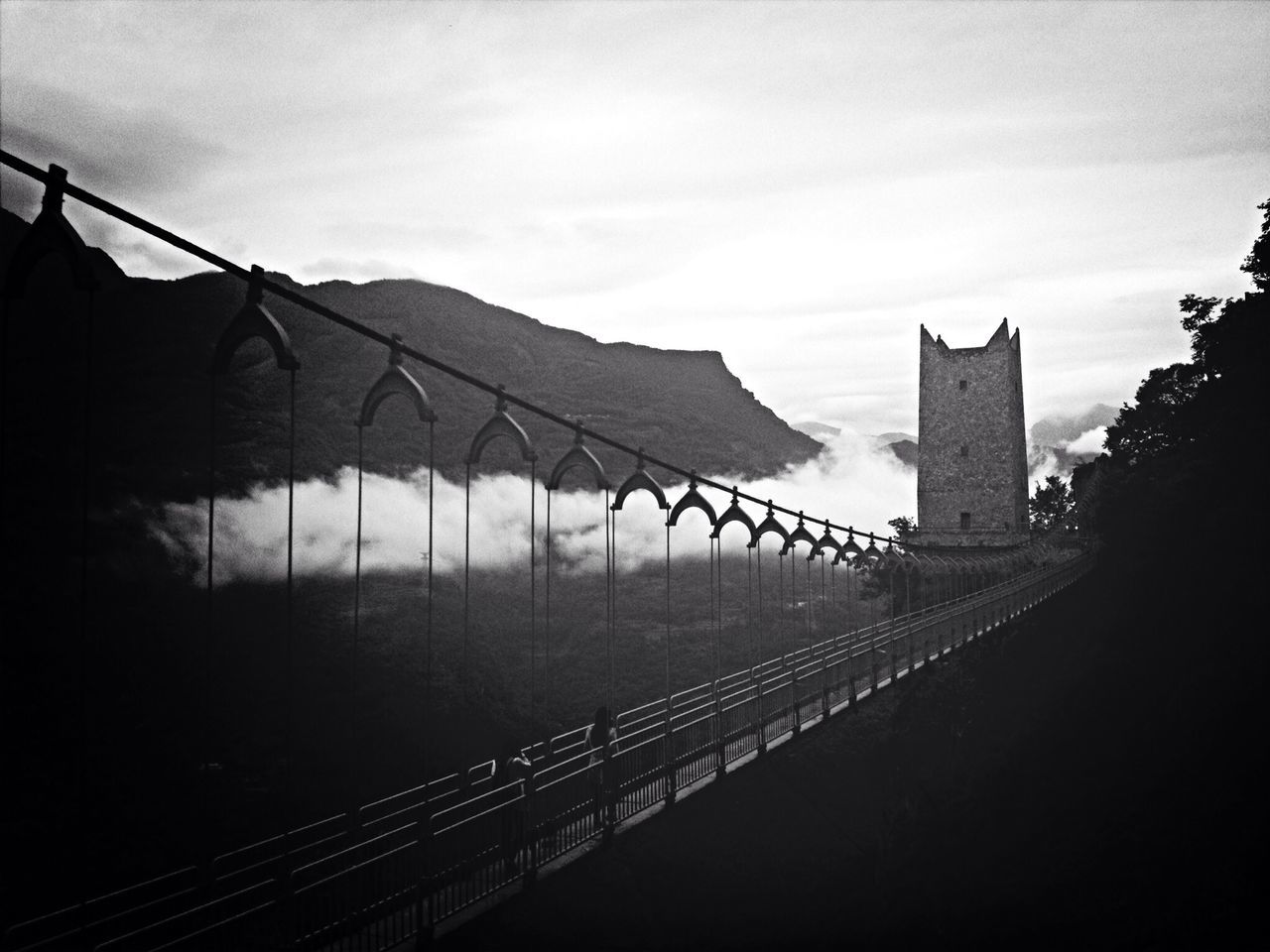 architecture, built structure, sky, building exterior, railing, bridge - man made structure, connection, cloud - sky, mountain, day, outdoors, tree, nature, cloud, no people, travel destinations, the way forward, sunlight, silhouette, city