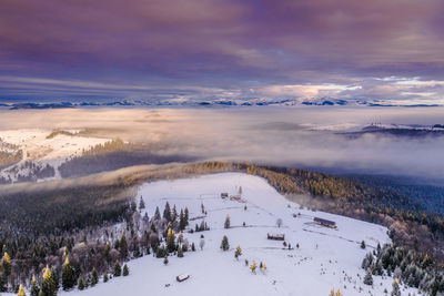 Scenic view of snow covered landscape against sky during sunset