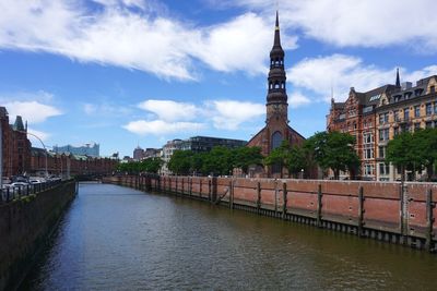 Arch bridge over river against buildings in city