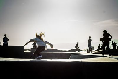 Woman skateboarding in park on sunny day