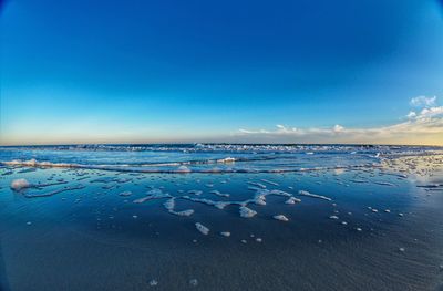 Scenic view of sea against blue sky