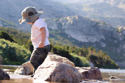 Man standing on rock against mountains