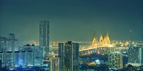 Illuminated cityscape against clear sky at night