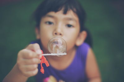 Close-up of girl holding bubble on wand
