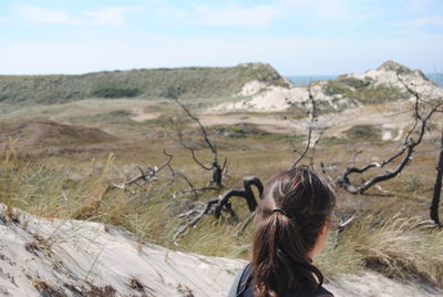 Rear view of woman walking on landscape against sky