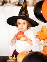 Portrait of cute girl wearing witch hat