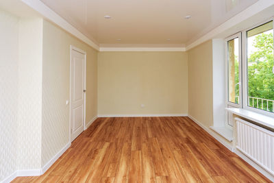 Empty bright room with a wooden floor and light wallpaper. the apartment is after renovation.