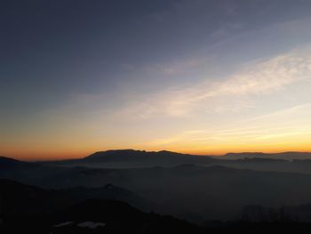 Scenic view of silhouette mountains against sky at sunset