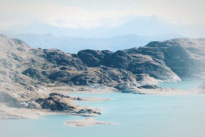 Scenic view of sea and mountains against sky