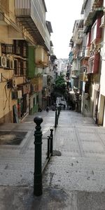 Empty road amidst buildings in city