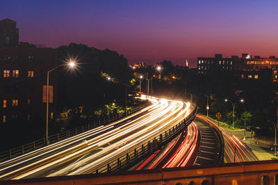 High angle view of light trails on bridges in city at dusk