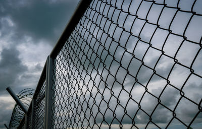 Military zone mesh fence. prison security fence. looking up view of barbed wire security fence.