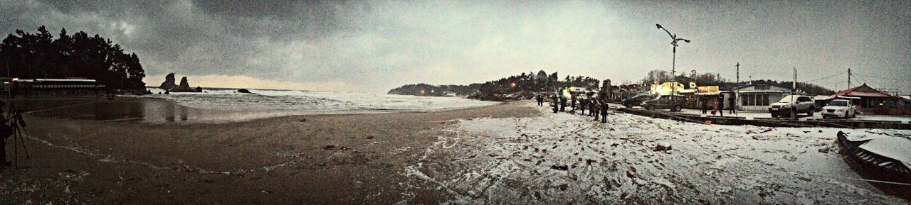 beach, sky, sand, shore, sea, water, cloud - sky, nature, tranquility, tranquil scene, scenics, building exterior, built structure, beauty in nature, incidental people, weather, architecture, outdoors, panoramic, cloud