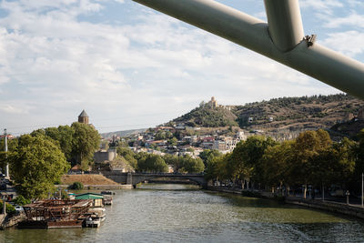 Bridge over river in city against sky